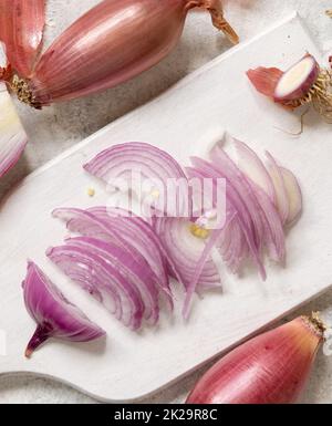 Rote tropea-Zwiebeln in Scheiben auf einem Whiteboard von oben Stockfoto