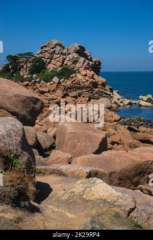 Monolithische Blöcke aus rosafarbenem Granit in den Cotes d'Armor in der Bretagne, Frankreich. Rosafarbene Granitküste Stockfoto