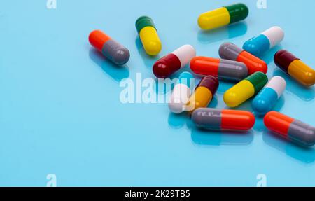 Antibiotische Kapselpillen auf blauem Hintergrund. Verschreibungspflichtige Medikamente. Farbige Kapselpillen. Antibiotikaresistenzkonzept. Pharmazeutische Industrie. Superbug-Probleme. Arzneimittel und Pharmakologie. Stockfoto