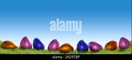 Farbenfrohe Ostereier in einer Reihe auf einem Grashintergrund, Osterkonzept Stockfoto