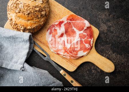 Italienischer Trockenschinken. Coppa Stagionata auf Schneidebrett. Stockfoto