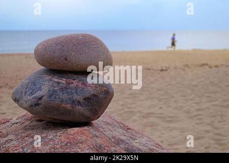 Zwei gestapelte Naturfelsen an einem Sandstrand Stockfoto