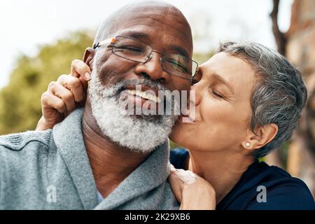 Unsere Liebe wird jeden Tag stärker. Aufnahme eines glücklichen älteren Paares, das eine schöne Zeit im Park genießt. Stockfoto