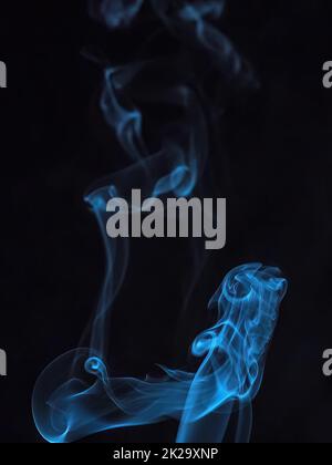 Nahaufnahme von farbenfrohem Rauch auf schwarzem Hintergrund. Abstrakte Rauchkurven und Wellen auf schwarzem Hintergrund. Stockfoto