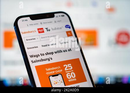 Sainsburys Mobile Website mit Laptop-Website im Hintergrund Stockfoto