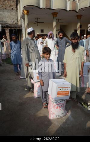 Peshawar, Khyber Pakhtunkhwa, Pakistan. 22. September 2022. Die von Überschwemmungen betroffenen Menschen erhalten von der Al Khidmat Foundation im Bezirk Nowshera, Dorf Garhi Momin, Provinz Khyber Pakhtunkhwa Hilfsgelder. (Bild: © Hussain Ali/Pacific Press via ZUMA Press Wire) Stockfoto