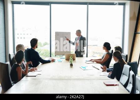 Alle an Bord des Projekts zu bringen. Aufnahme einer Gruppe von Führungskräften, die in einem Sitzungssaal ein Meeting abhalten. Stockfoto