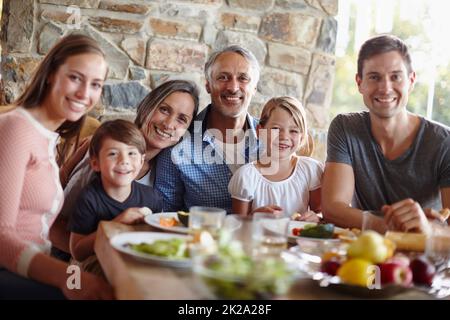 Liebend, fürsorglich, teilend - das ist Familie. Ein Porträt einer glücklichen, generationsübergreifenden Familie, die gemeinsam im Freien essen geht. Stockfoto