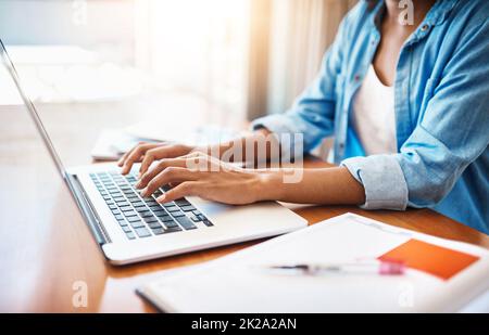 Harte Arbeit über das Wochenende. Aufnahme einer jungen Frau, die zu Hause an ihrem Laptop arbeitet. Stockfoto