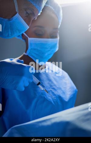 Anästhesiisierung des Patienten. Aufnahme einer Gruppe von Chirurgen, die an einem Patienten in einem Operationssaal arbeiten. Stockfoto