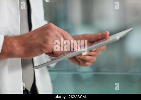 Verfolgen des Fortschritts eines Patienten. Nahaufnahme eines nicht erkennbaren Arztes mit einem digitalen Tablet. Stockfoto