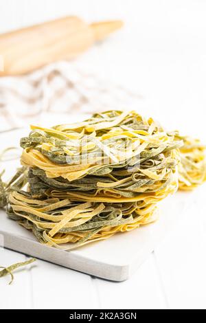 Eiernudeln. Nudeln mit Spinatgeschmack auf einem weißen Tisch nisten. Stockfoto