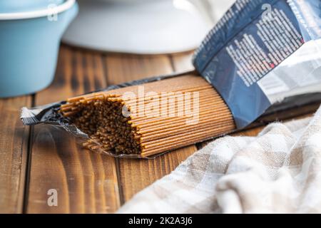 Nicht gekochte Vollkornspaghetti. Rohe Pasta auf Holztisch. Stockfoto