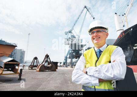 Ich lebe für meinen Job. Ein Hafenarbeiter, der mitten in der Schifffahrt am Hafen steht. Stockfoto