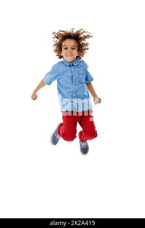 Springen vor Freude. Studioaufnahme eines niedlichen kleinen Jungen, der vor Freude vor weißem Hintergrund springt. Stockfoto