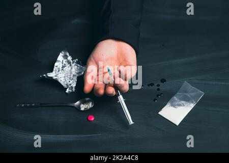 Drogenabhängiger mit Spritzen unter Drogeneinfluss. Stockfoto