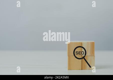 Holzwürfel mit Lupe Symbol und AkronymSEO.Digital Marketing Strategie SEO Search Engine Optimization Ranking Konzepte. Stockfoto