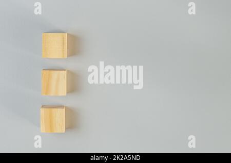 Leere Holzwürfel für Symbole oder Symbole auf grauem Hintergrund. Stockfoto