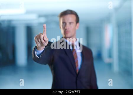 Unternehmenstools mit einer einfachen Berührung. Eine kleine Aufnahme eines hübschen jungen Geschäftsreisenden, der eine digitale Schnittstelle verwendet. Stockfoto