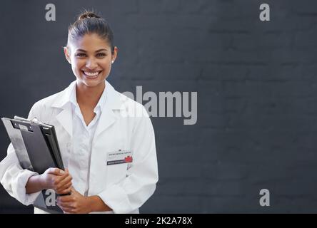 Freut mich zu heilen. Ausgeschnittene Aufnahme eines lächelnden jungen Arztes. Stockfoto