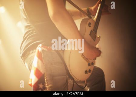 Super krank solo. Ein Gitarrist, der ein krankes Solo aufführt, während er mit seiner Band bei einem vollgepackten Gig rockt. Stockfoto