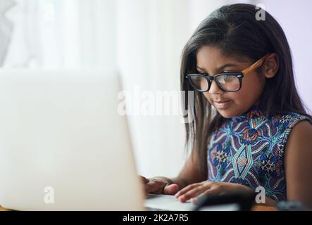 Warum zahlen Porto, wenn Sie E-Mail Oma statt. Aufnahme eines niedlichen kleinen Mädchens, das in ihrem Schlafzimmer zu Hause einen Laptop benutzt. Stockfoto