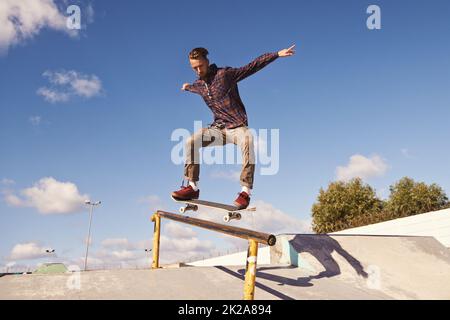 Wie Fliegen. Aufnahme eines Skateboarders, der einen Trick auf einer Schiene ausführt. Stockfoto