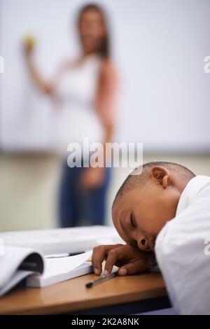 Einschlafen in der Klasse. Ein kleiner Junge, der in der Klasse schläft. Stockfoto