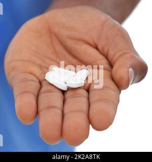 DEPENDANT auf Medicat. Beschnittene Ansicht einer mans Hand, die einige weiße Pillen aushält. Stockfoto