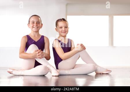 Ballerinas in der Herstellung. Fröhliche junge Ballerinas, die in einem Ballettstudio sitzen. Stockfoto