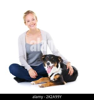 Hes ein so guter Junge. Studioaufnahme einer jungen Frau mit ihrem Hund auf Weiß isoliert. Stockfoto