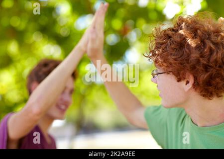 Waren super. Eine kurze Aufnahme von zwei Teenagern, die sich gegenseitig einen High-Five gaben. Stockfoto