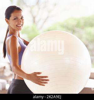 Bereit für den Ball. Porträt einer schönen jungen Frau, die zu Hause einen Übungsball hält. Stockfoto