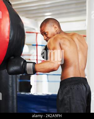 Verfeinert seine Technik. Ein afroamerikanischer Boxer, der mit einem Boxball trainiert. Stockfoto