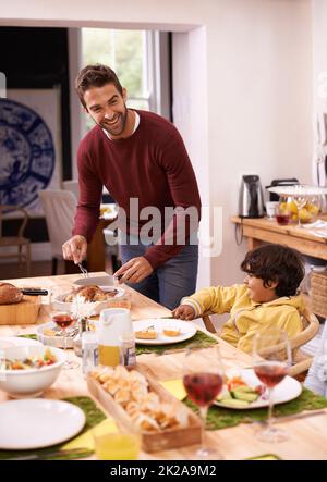 Lasst uns stecken bleiben. Ein Vater und ein Sohn genießen ein Familienessen. Stockfoto