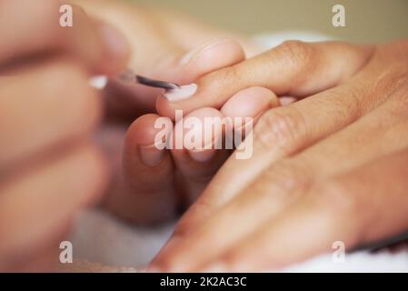 Schönheit auf Knopfdruck. Eine kurze Aufnahme einer Frau, die ihre Nägel malte. Stockfoto