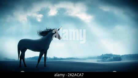 Glauben Sie dem Unglaublichen. Aufnahme eines schönen Einhorns gegen eine dramatische Landschaft. Stockfoto