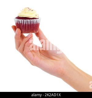 Frostige Güte. Nahaufnahme einer Frau, die einen Cupcake auf Weiß hält. Stockfoto