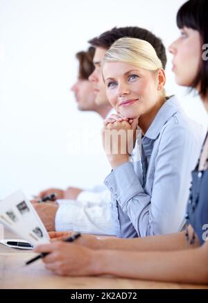 Tagträumen von Sommerferien. Porträt einer hübschen Geschäftsfrau, die während eines Meetings lächelt. Stockfoto