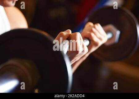 Entschlossenheit ist der Schlüssel zur Stärke. Schöner sportlicher Mann im Fitnessstudio, der Übungen macht. Stockfoto