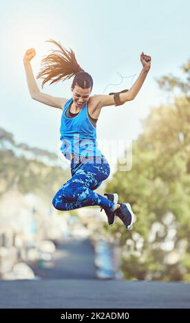 Harte Arbeit bleibt nie unbemerkt. Aufnahme einer jungen Frau, die nach dem Training in der Luft springt. Stockfoto