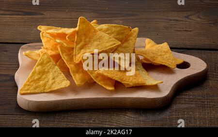 Ein Haufen Tortilla-Chips oder Nachos auf braunem Holzhintergrund Stockfoto