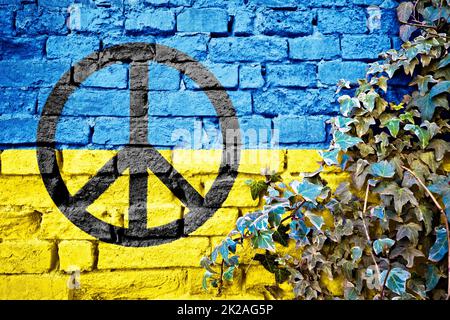 Grunge-Flagge der Ukraine mit Friedenszeichen an der Ziegelwand mit Efeu-Pflanze Stockfoto