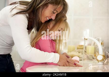 Es ist so wichtig, sich die Hände zu waschen Aufnahme einer Mutter, die ihrer Tochter beibringt, wie sie sich die Hände waschen soll. Stockfoto