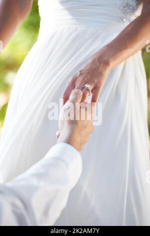 Mit diesem Ring habe ich dich verwoben Zugeschnittenes Bild eines Bräutigams, der seine Bräute in die Hand nimmt. Stockfoto