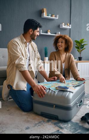 Ein glückliches, junges Familienpaar, das einen Urlaub plant Stockfoto