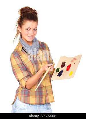 Bereit, mein Meisterwerk zu malen. Studioporträt einer attraktiven jungen Frau, die einen Pinsel und eine Staffelei isoliert auf Weiß hält. Stockfoto