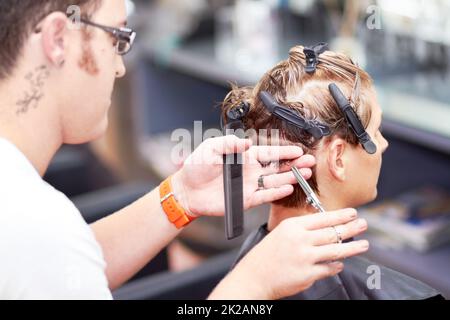 So hat sie den perfekten Schnitt. Eine junge Frau, die beim Friseur einen Haarschnitt bekommt. Stockfoto