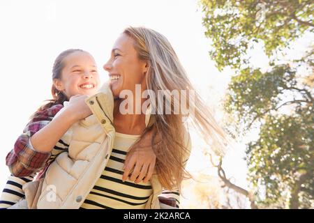 Spielerische Familienbindung. Eine glückliche Mutter und Tochter verbringen Zeit zusammen im Freien. Stockfoto