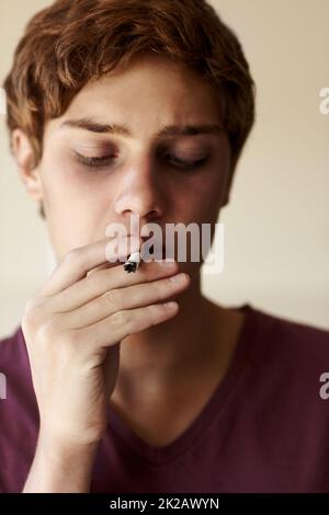 Einfach mal ausprobieren Nahaufnahme einer Person, die eine Zigarette raucht. Stockfoto